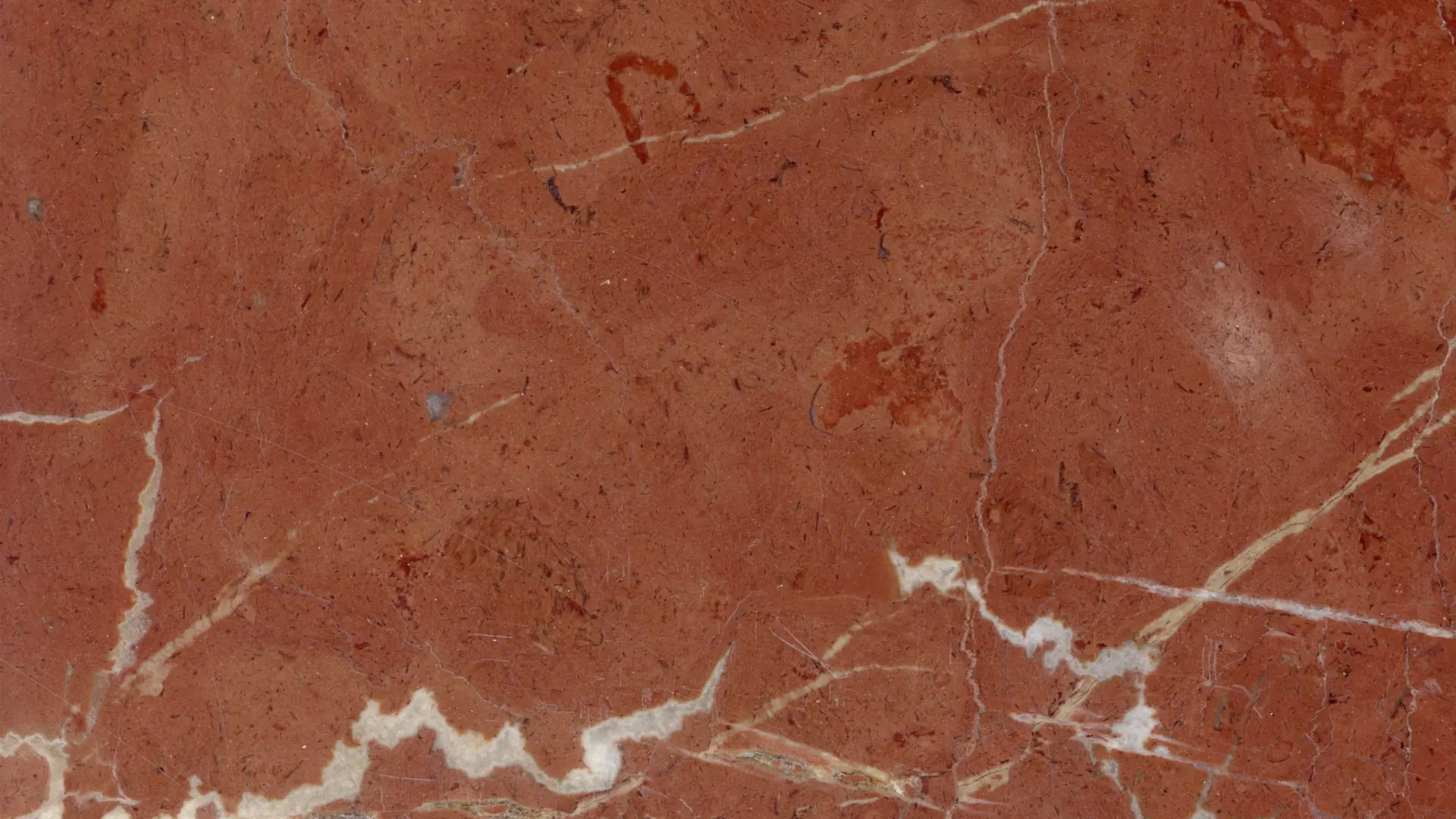 Primer plano de una encimera de mármol Rojo Alicante con veta blanca